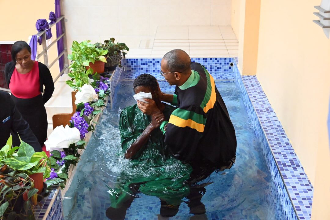 A baptism being performed in the sanctuary's baptistry