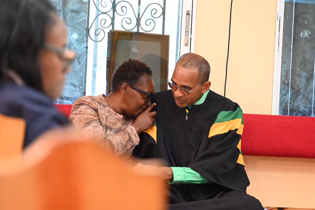 An elder praying with and comforting a church member